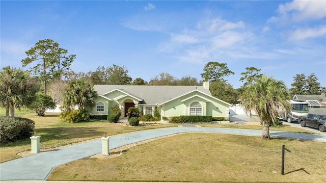 ranch-style home with driveway and a front yard