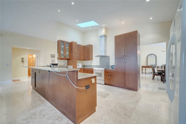 kitchen with white appliances, a skylight, a towering ceiling, glass insert cabinets, and light countertops