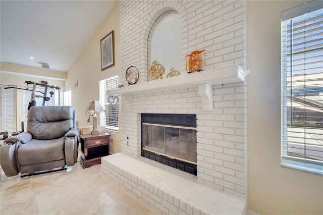 living area featuring high vaulted ceiling, a fireplace, and visible vents