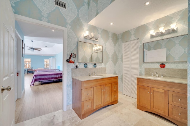 full bathroom with visible vents, two vanities, a sink, and ensuite bathroom