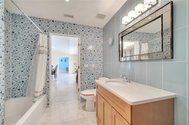 bathroom with visible vents, toilet, shower / bath combination with curtain, and tile walls