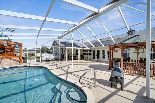 pool with glass enclosure, french doors, and a patio area