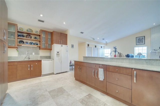 kitchen with white appliances, visible vents, glass insert cabinets, brown cabinets, and a sink