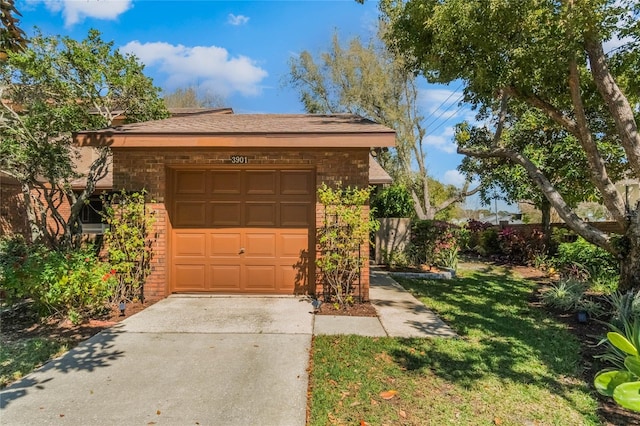 garage with concrete driveway and fence