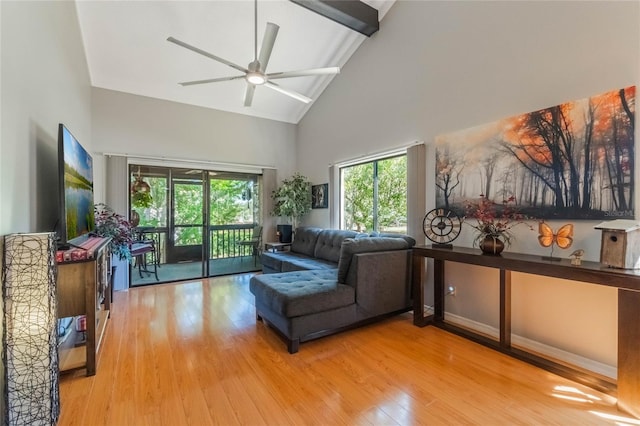 living room featuring beam ceiling, wood-type flooring, a ceiling fan, high vaulted ceiling, and baseboards