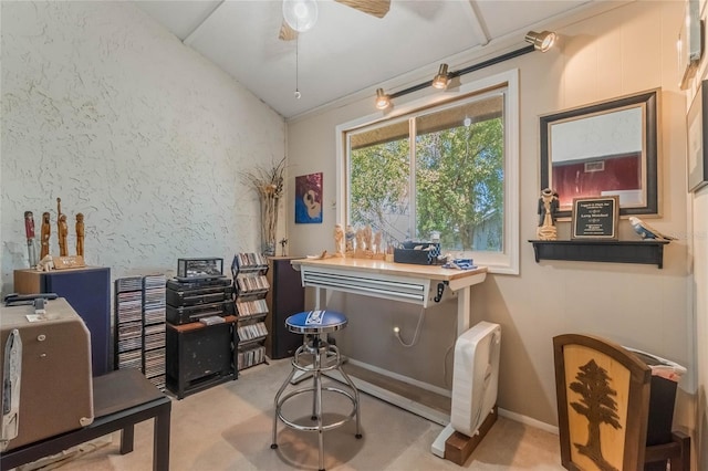 carpeted home office featuring lofted ceiling and ceiling fan