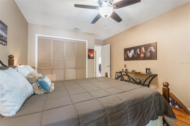 bedroom featuring a textured ceiling, a closet, visible vents, and a ceiling fan