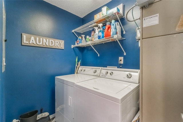 laundry area with a textured ceiling, laundry area, and washer and clothes dryer