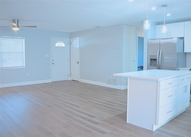 kitchen featuring a kitchen island, stainless steel fridge with ice dispenser, open floor plan, light wood-style floors, and white cabinets