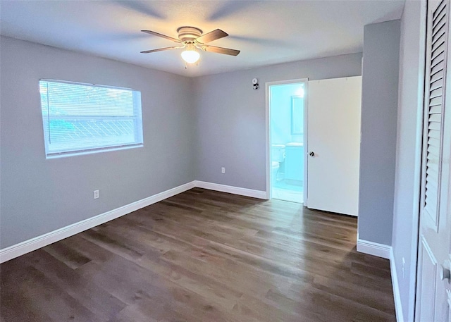 unfurnished bedroom with ceiling fan, ensuite bathroom, baseboards, and wood finished floors