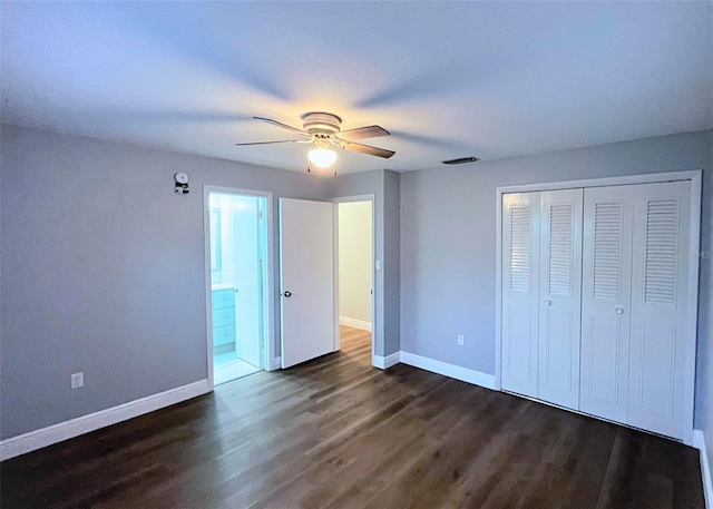 unfurnished bedroom featuring a closet, baseboards, and dark wood-style flooring