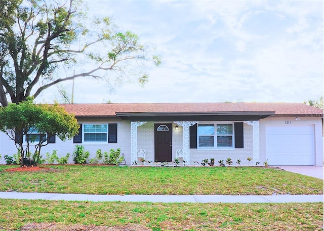 ranch-style home featuring a garage, brick siding, concrete driveway, and a front lawn