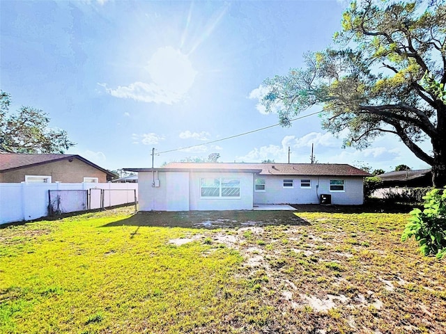 back of house with a yard and fence