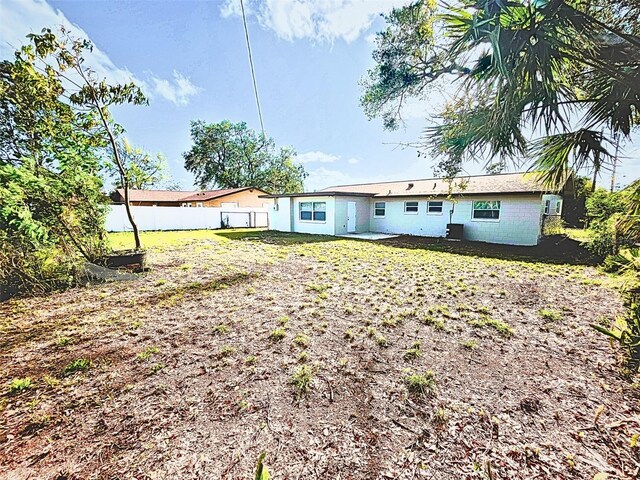 back of property featuring a yard and fence