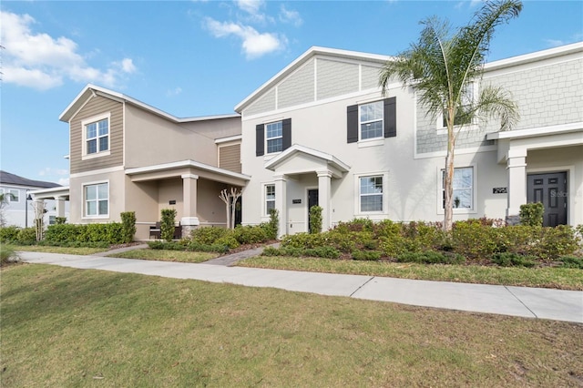 multi unit property featuring stucco siding and a front lawn