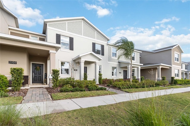 view of property featuring stucco siding and a front yard