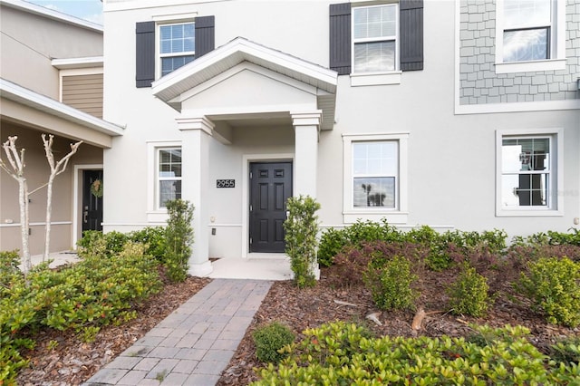 entrance to property featuring stucco siding