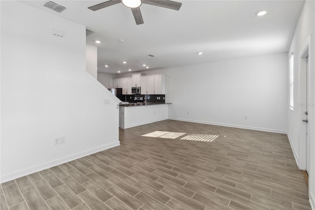 unfurnished living room with visible vents, light wood-style flooring, a ceiling fan, recessed lighting, and baseboards