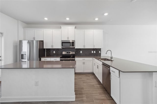 kitchen with a sink, stainless steel appliances, backsplash, and a center island