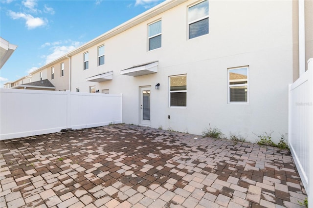 back of house featuring a patio, fence, and stucco siding