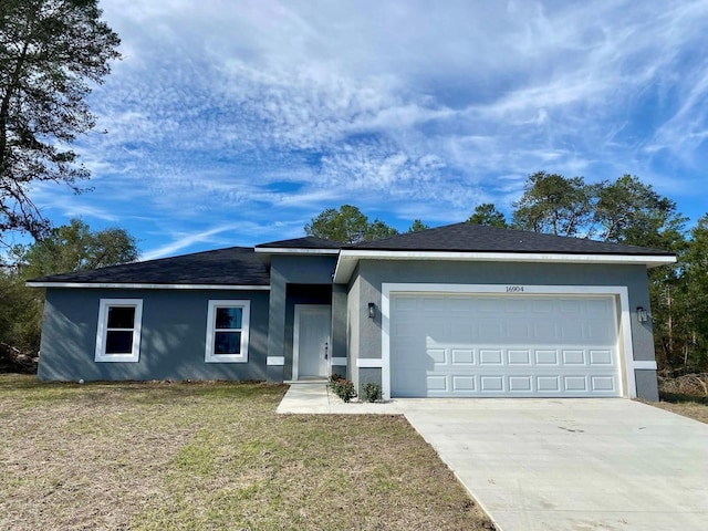 single story home with a front yard, concrete driveway, an attached garage, and stucco siding