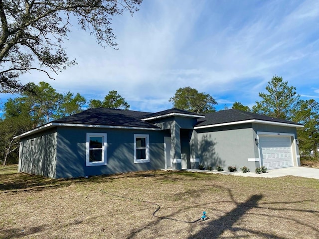 ranch-style home featuring driveway, stucco siding, an attached garage, and a front yard