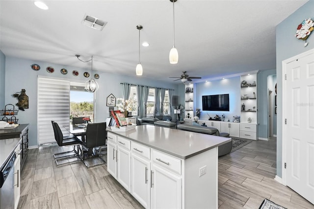 kitchen with visible vents, a kitchen island, stainless steel dishwasher, white cabinetry, and wood tiled floor