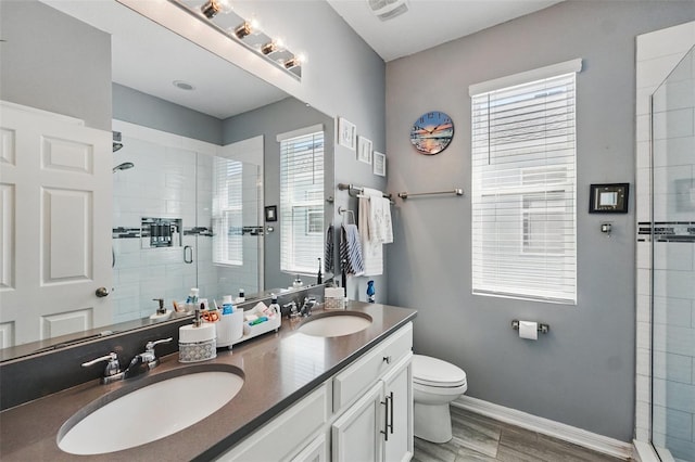 full bath featuring visible vents, a stall shower, baseboards, and a sink