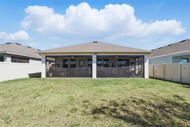 back of house with a yard, a fenced backyard, and a sunroom