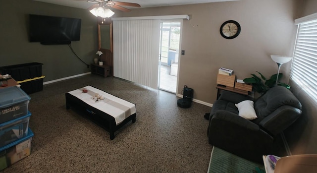 living room featuring a ceiling fan, baseboards, and speckled floor