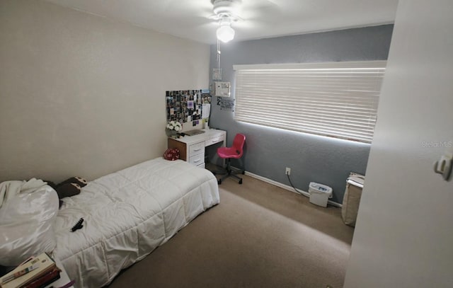 carpeted bedroom with a ceiling fan and baseboards