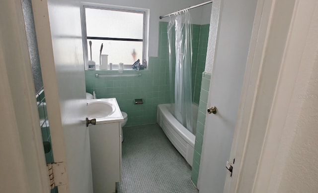 bathroom with toilet, vanity, tile walls, tile patterned floors, and shower / bathtub combination with curtain