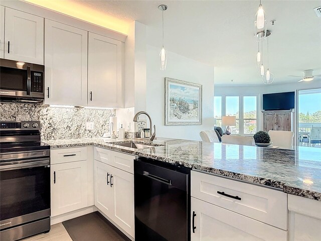 kitchen featuring a sink, stone countertops, appliances with stainless steel finishes, and decorative backsplash