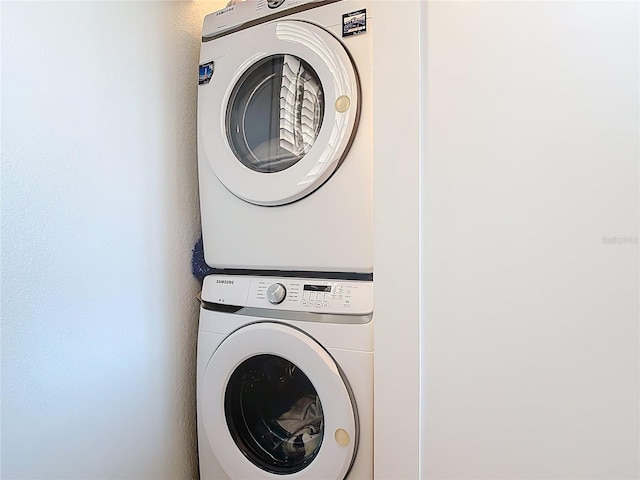 washroom with stacked washer and clothes dryer and laundry area