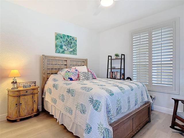 bedroom featuring baseboards, wood finished floors, and a ceiling fan