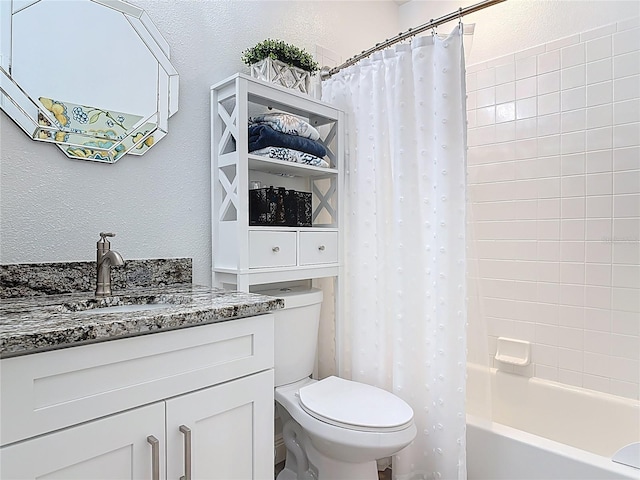 full bath featuring shower / tub combo, toilet, vanity, and a textured wall