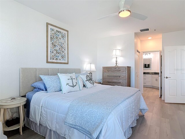 bedroom featuring visible vents, connected bathroom, a ceiling fan, and light wood finished floors