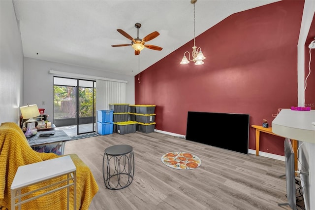 living room with ceiling fan with notable chandelier, lofted ceiling, baseboards, and wood finished floors