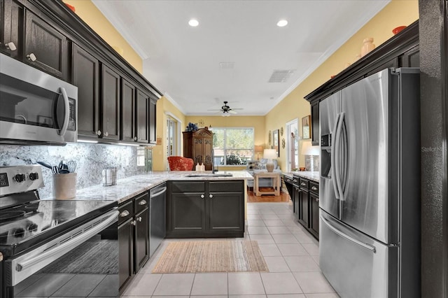 kitchen with visible vents, light tile patterned flooring, ornamental molding, appliances with stainless steel finishes, and open floor plan