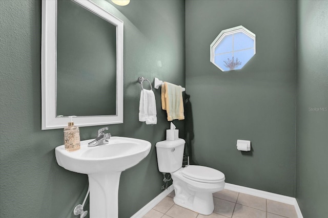 bathroom featuring tile patterned flooring, toilet, and baseboards