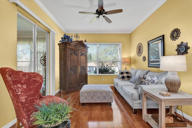 living room with ceiling fan, crown molding, baseboards, and hardwood / wood-style flooring