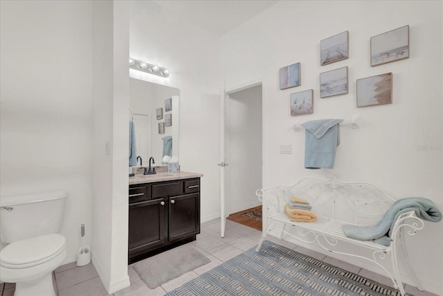 bathroom featuring tile patterned flooring, toilet, vanity, and baseboards