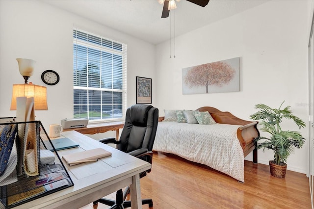 bedroom with a ceiling fan, wood finished floors, and baseboards