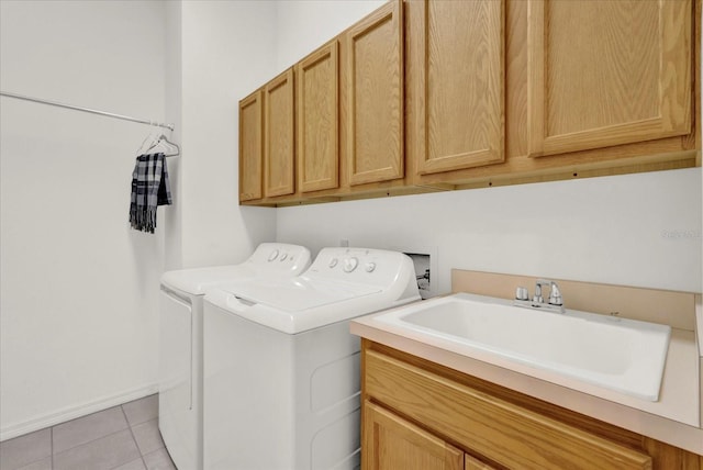 clothes washing area featuring washing machine and clothes dryer, cabinet space, light tile patterned flooring, and a sink