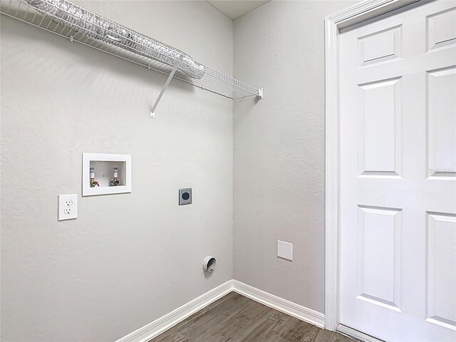 laundry room featuring electric dryer hookup, dark wood-type flooring, baseboards, hookup for a washing machine, and laundry area