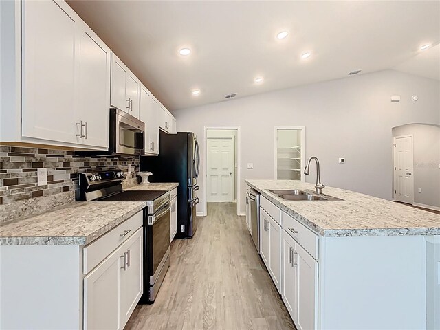 kitchen featuring a sink, vaulted ceiling, light countertops, and stainless steel appliances