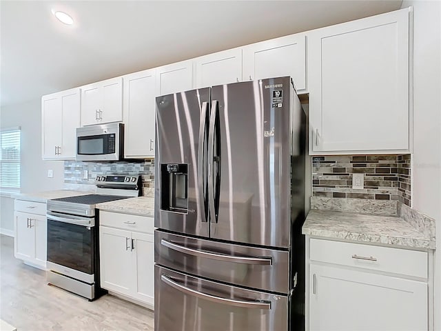 kitchen featuring white cabinetry, tasteful backsplash, appliances with stainless steel finishes, and light countertops