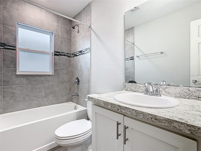 bathroom featuring vanity,  shower combination, toilet, and visible vents