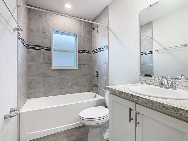 bathroom featuring visible vents, toilet, shower / bathtub combination, wood finished floors, and vanity