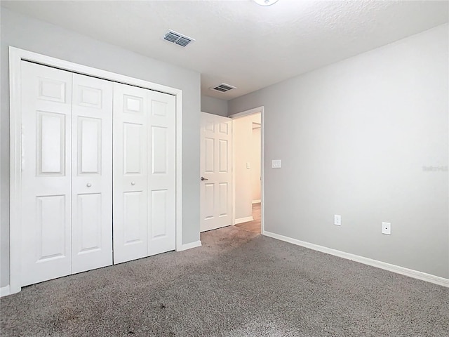 unfurnished bedroom featuring a closet, visible vents, baseboards, and carpet floors